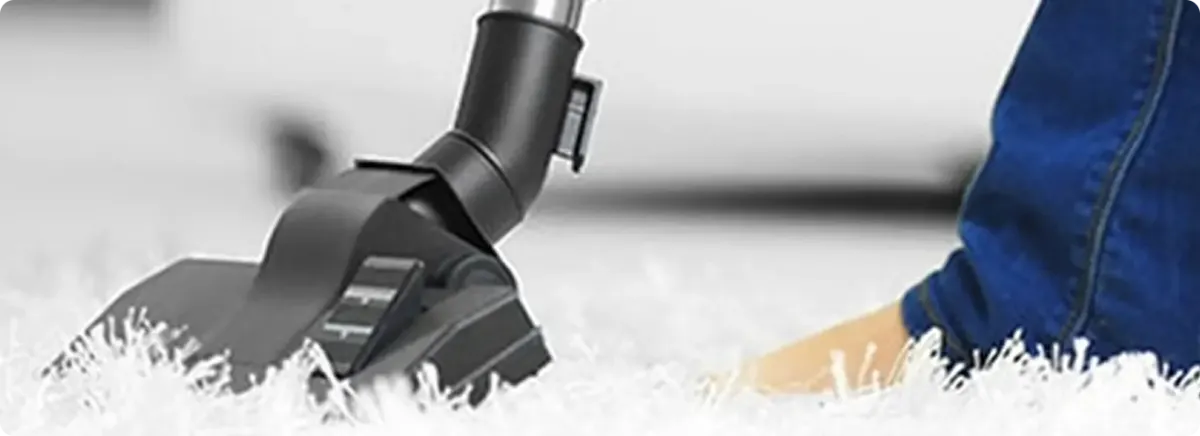 Close-up of a professional vacuuming a white carpet in Hurst.